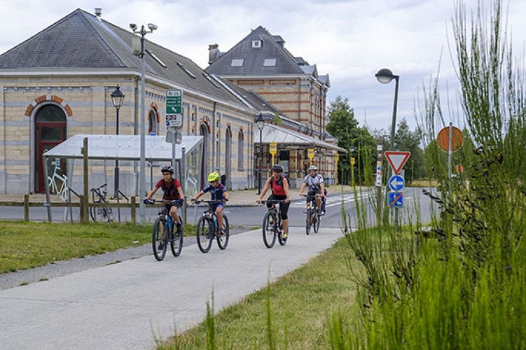 Cyclistes sur le RAVeL devant l'ancienne gare de Bastogne