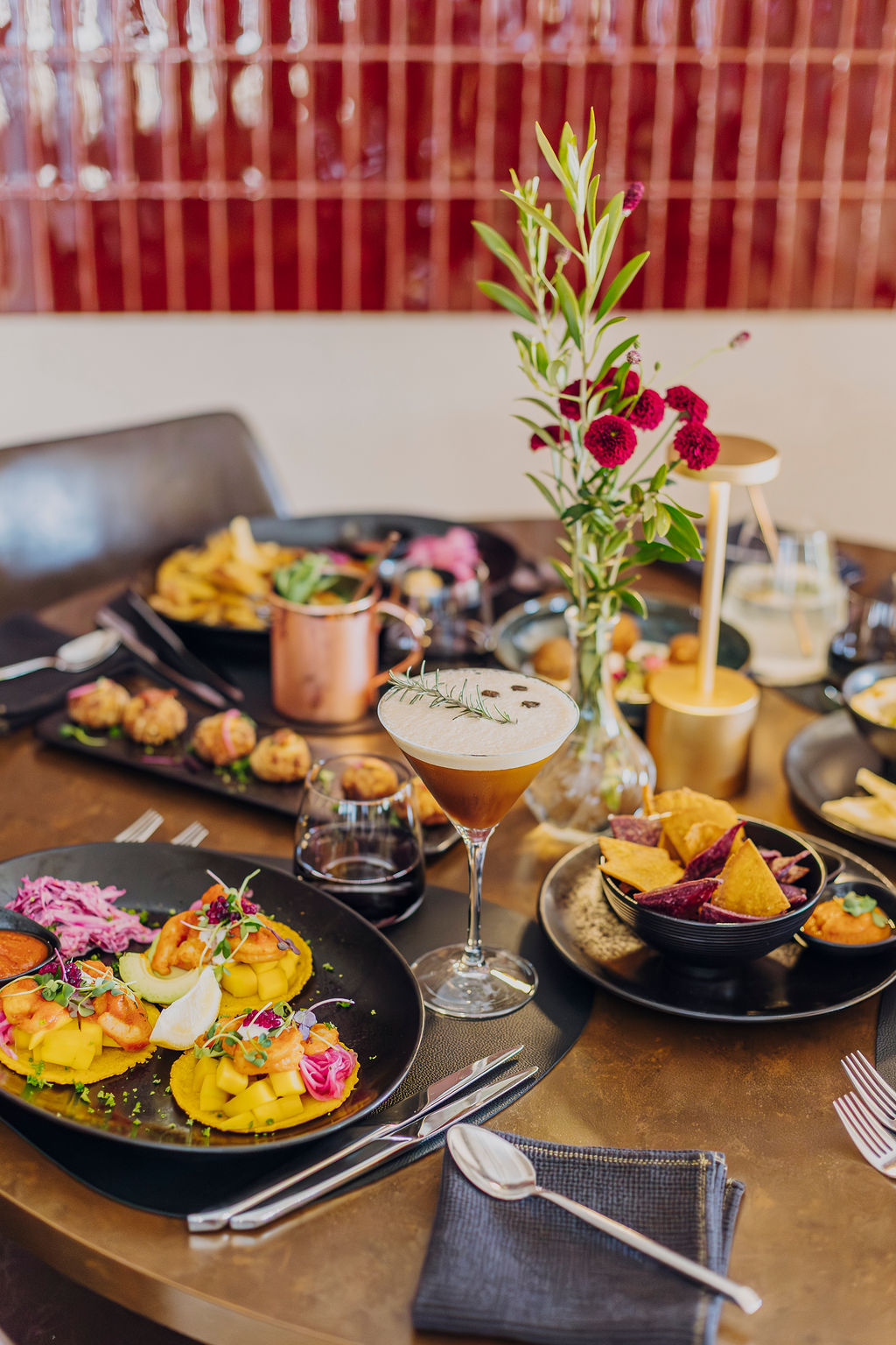 Table du Mel'ting Pot garnie de plats à partager et de fleurs, Maison Melba