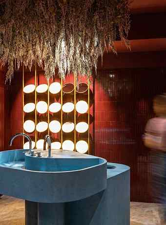 Blue washbasin and illuminated mirror in the Maison Melba restrooms