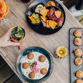 Bols et tapas faits maison sur une table en bois du Mel'ting Pot à Bastogne