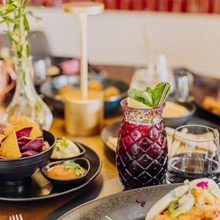 Cocktail aux fruits rouges et plats colorés au restaurant Mel'ting Pot