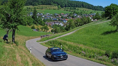 Voiture sur une route sinueuse dans les collines des Ardennes