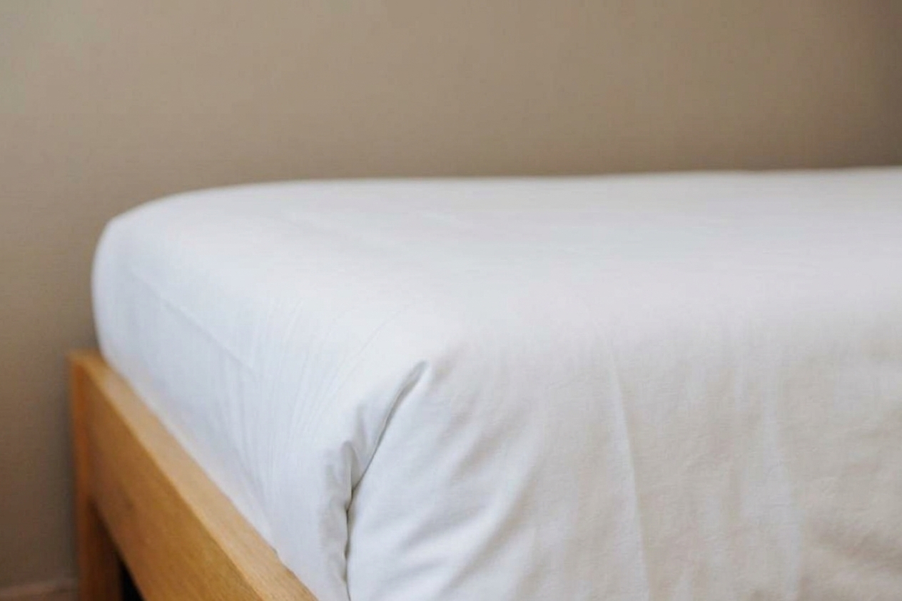 Gros plan sur un lit d'appoint aux draps blancs, Maison Melba