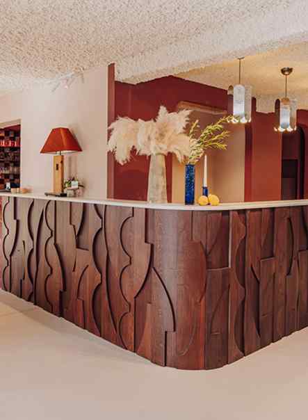 Comptoir de réception en bois sculpté et décoration fleurie, Maison Melba Bastogne