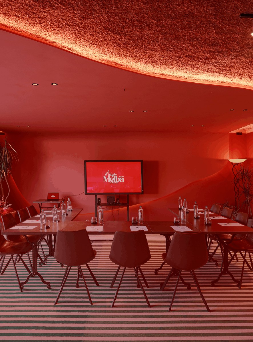 Salle de réunion rouge avec écran de présentation, Maison Melba