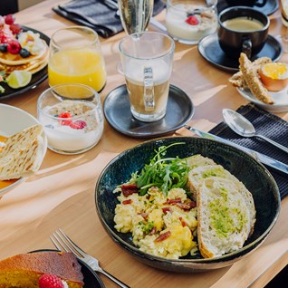 Assiettes de brunch et jus d'orange au restaurant Mel'ting Pot de Maison Melba