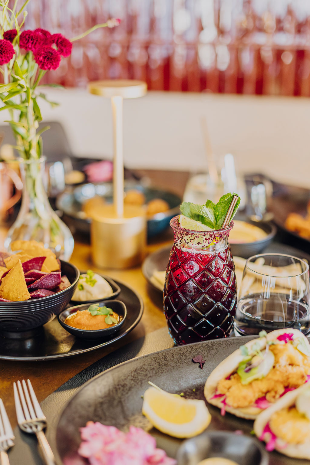 Plats colorés et cocktails sur une table dressée du Mel'ting Pot
