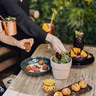 Serveur apportant cocktails et tapas au restaurant Mel'ting Pot de Maison Melba