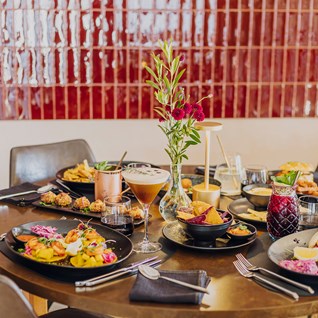 Plats à partager et fleurs sur une table du restaurant Mel'ting Pot à Bastogne