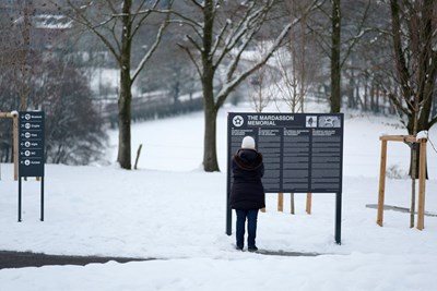 Promeneur devant des panneaux d'information dans la neige au Mardasson en hiver