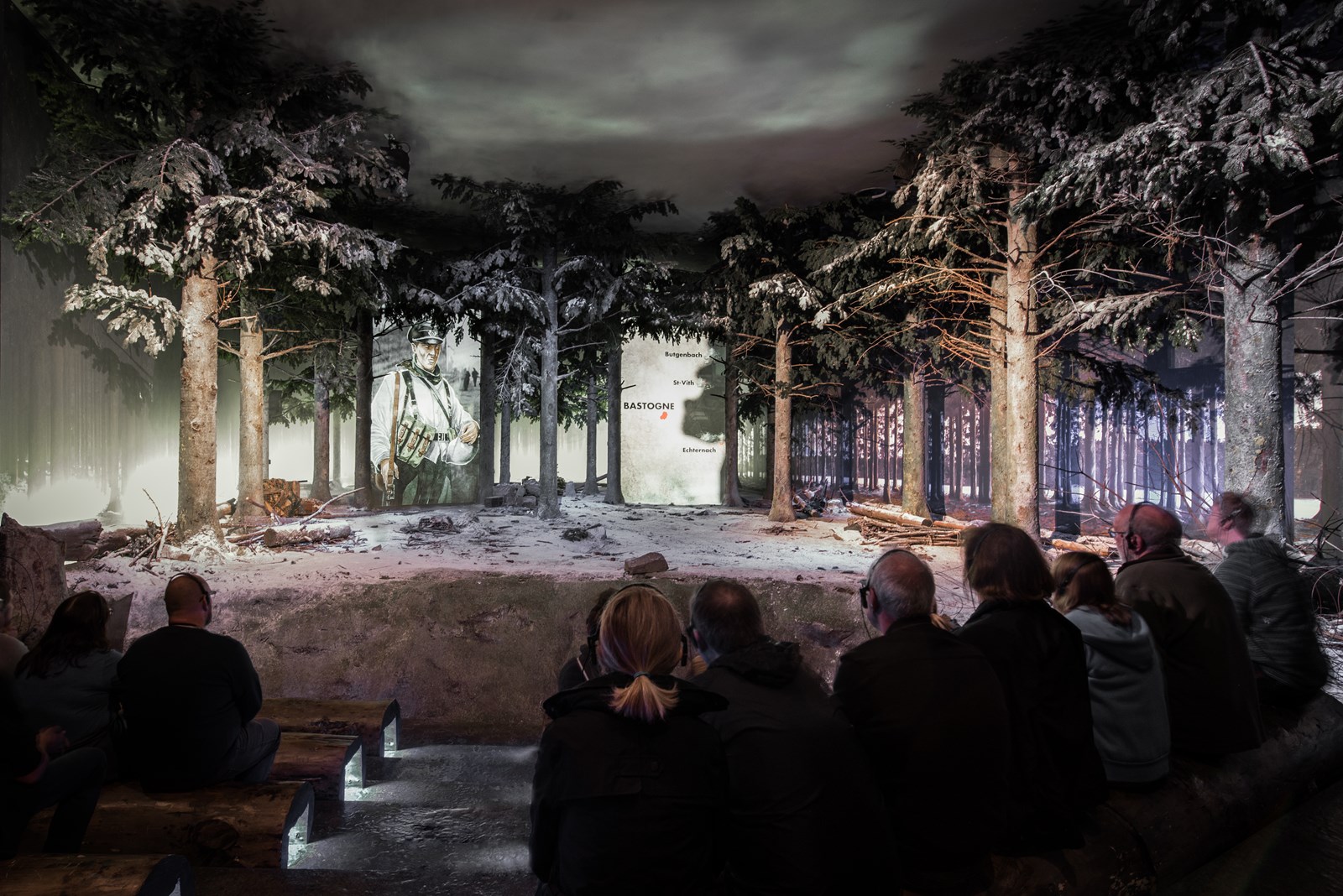 Visiteurs devant la scénographie immersive d'un musée de la Bataille des Ardennes à Bastogne