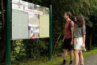 Randonneurs devant un panneau d'information lors d'une randonnée mémoire