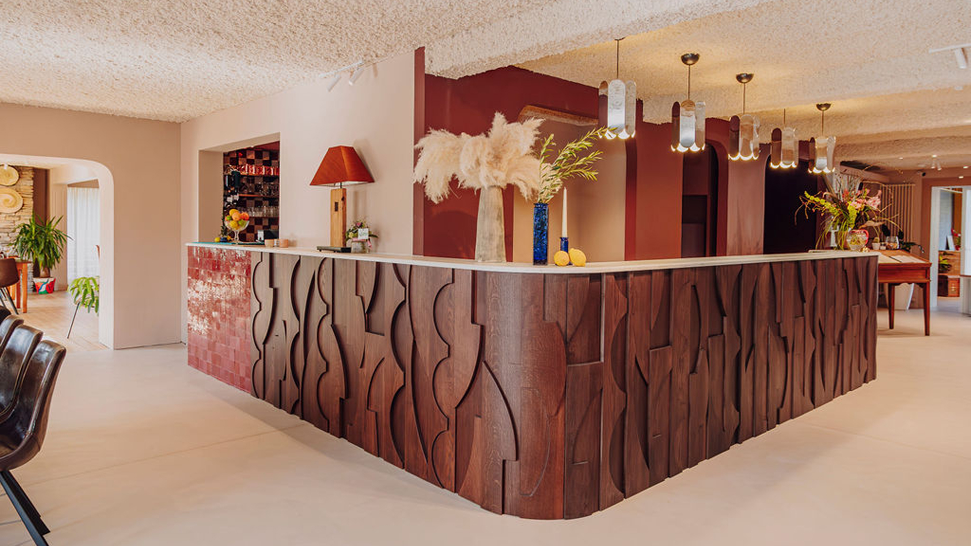Réception de Maison Melba, hôtel familial à Bastogne, avec comptoir en bois sculpté