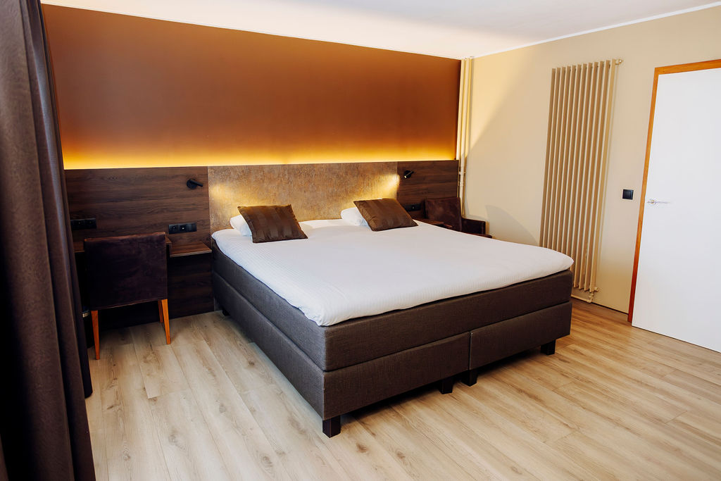 Chambre exécutive avec lit double et parquet clair, hôtel 4 étoiles à Bastogne