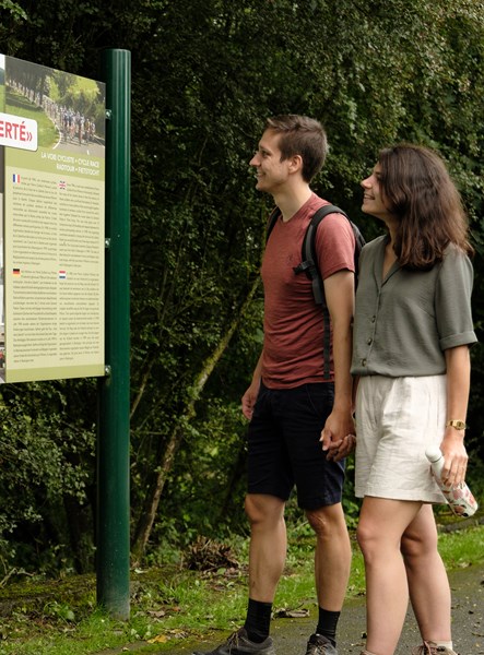 Randonneurs devant un panneau d'information lors d'une randonnée mémoire
